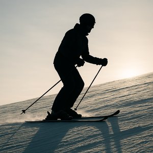 Backlit Skier Silhouette on Winter Slope